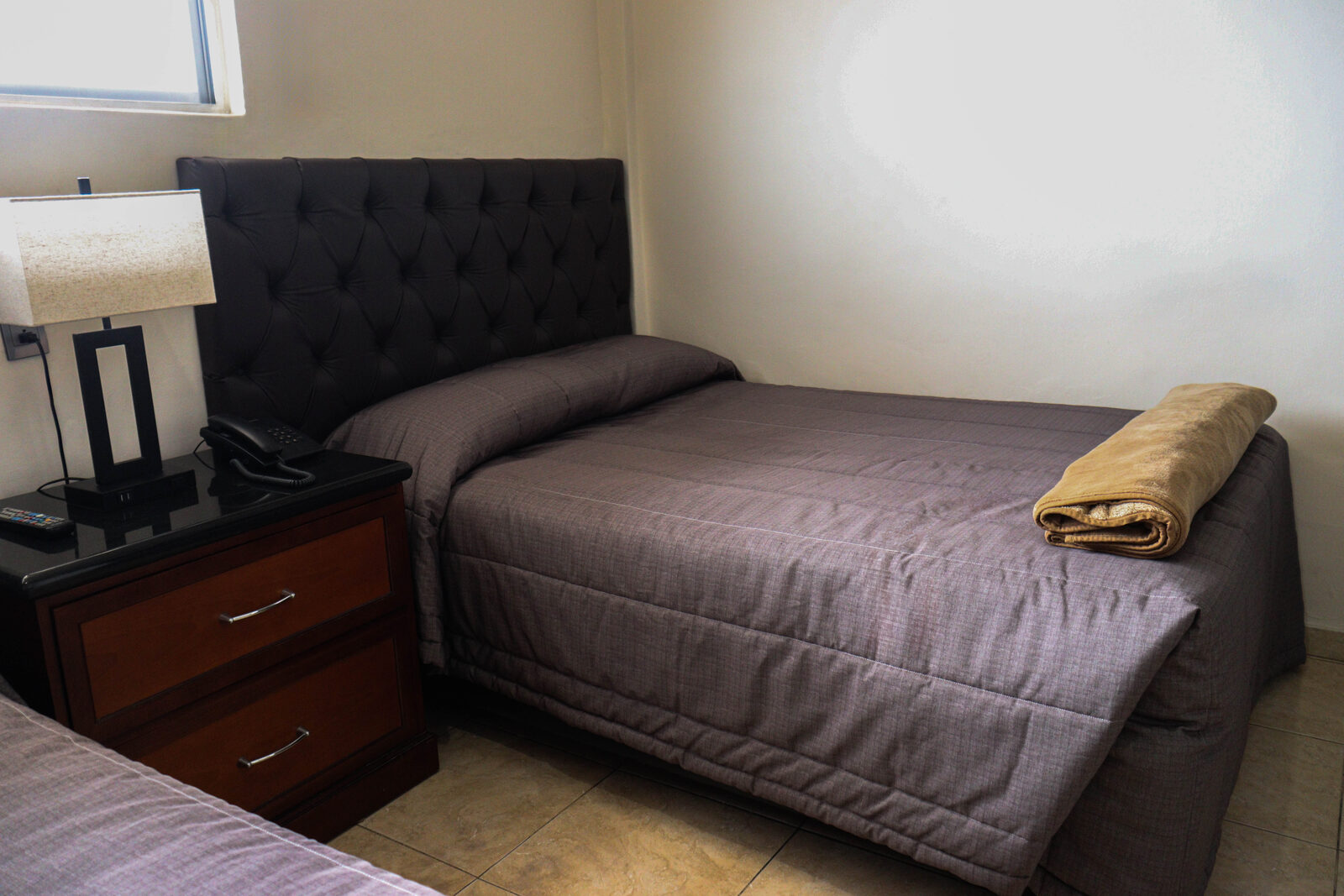 Cama y buró con lámpara y teléfono