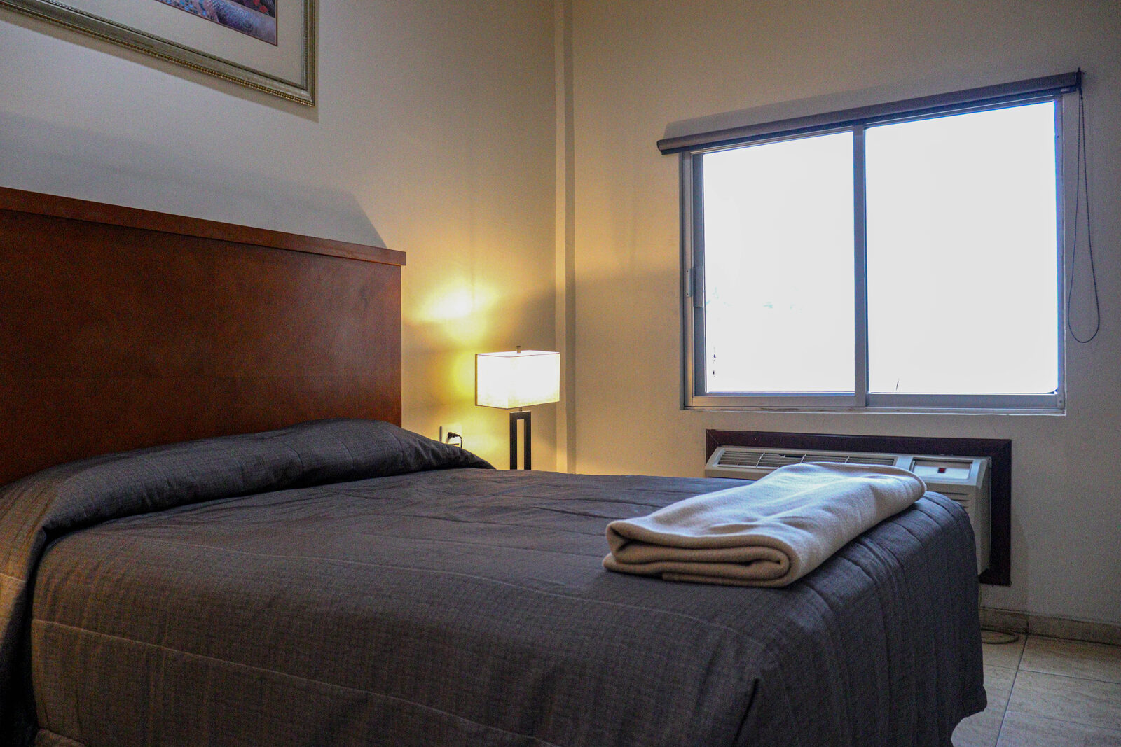 Cama y ventana con aire acondicionado