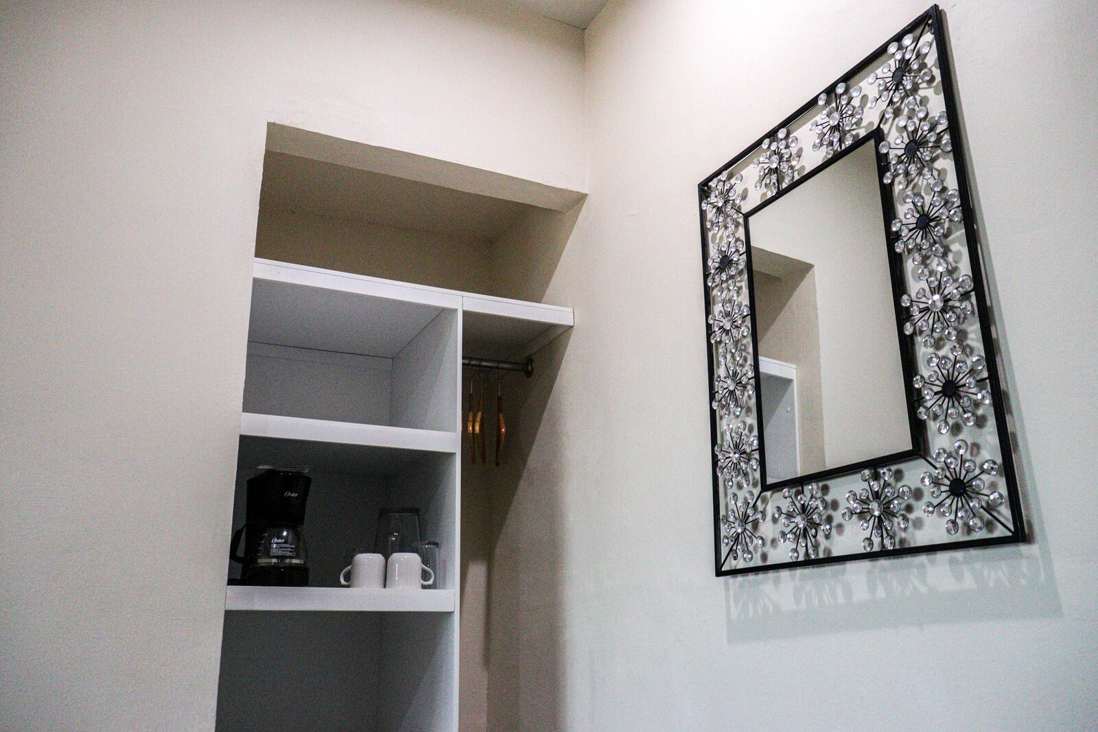 Closet con cafetera y espejo decorativo